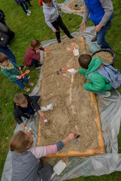 Children tried their hand at uncovering dinosaur bones from a paleontological dig.
